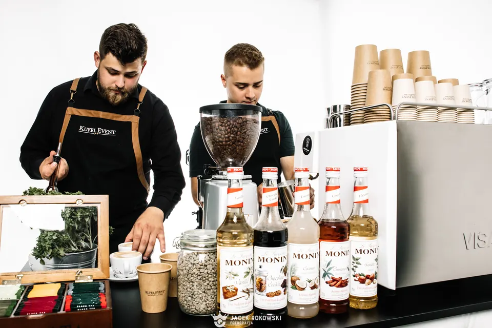 Dwóch baristów przygotowuje kawę przy coffee barze