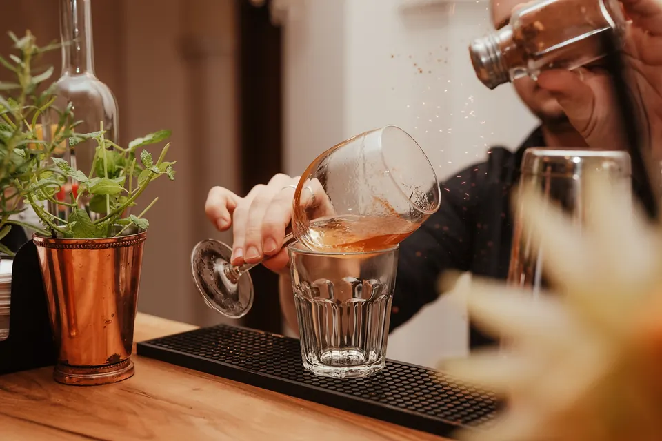 Barman przelewa koktajl do szklanki